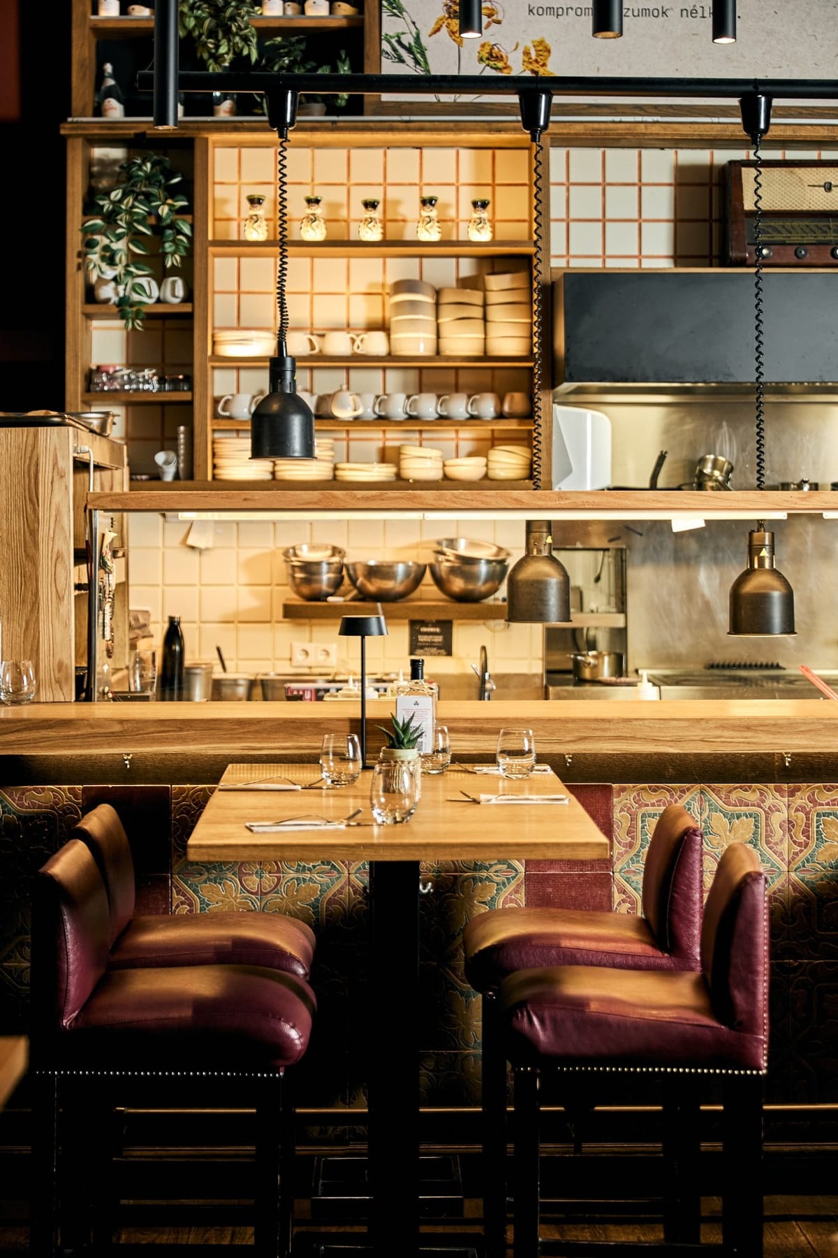 Kismező’s dining room with an open kitchen, wooden tables and burgundy chairs